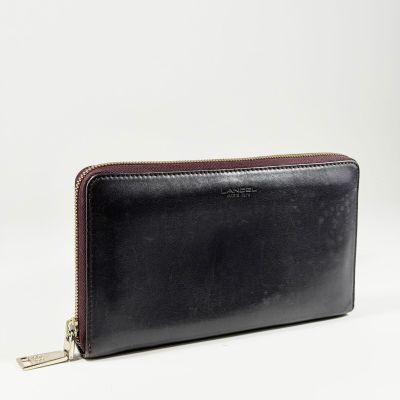le portefeuille en cuir noir est ouvert sur une surface blanche