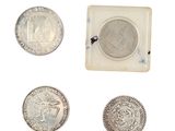four different types of silver coins are shown in a small box