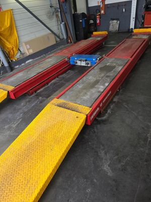 des rampes jaunes et rouges dans un entrepôt, avec une voiture bleue en arrière-plan