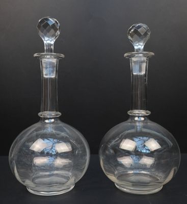 une paire de carafes en verre transparent posées sur un support noir