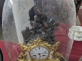 a clock under a glass dome on a table