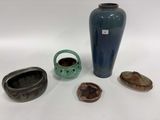 un vase bleu, un bol et d'autres objets posés sur une table