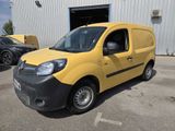 the small yellow van is parked in front of a building