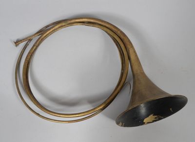 an old brass trumpet with a long horn on a white surface