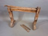a piece of wood that is sitting next to a pair of nails