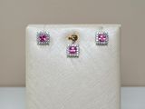 un gros plan sur une paire de boucles d'oreilles roses et blanches