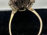 a close up of a gold ring with a black diamond center