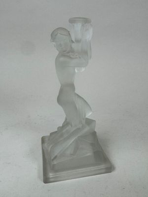 statue d'une femme tenant un vase, posée sur un socle, sur une surface blanche
