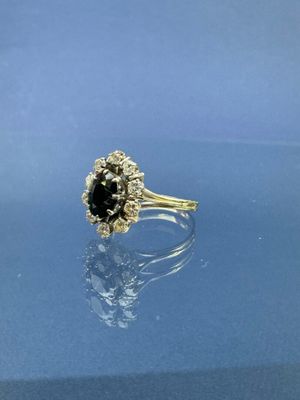 un gros plan d'une bague sertie d'un diamant noir sur une surface bleue