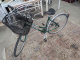 a bicycle with a basket attached to it sitting on a rug
