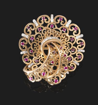 un gros plan d'une broche en or sertie de rubis et de diamants