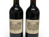 deux bouteilles de vin rouge posées l'une à côté de l'autre sur une surface blanche