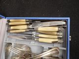 silverware in a blue box on a black surface