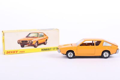 an orange toy car sitting next to a boxed box on a white surface