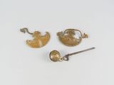 three pieces of gold and silver jewelry on a white surface