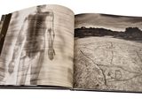 an open book with a picture of a person standing in a field