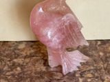 a pink bird that is sitting on a table