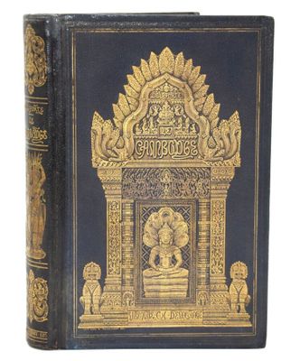 un vieux livre à la couverture dorée et noire posé sur une table