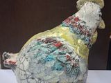a ceramic sculpture of a chicken on display on a table