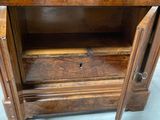 a wooden cabinet with a door open on the floor