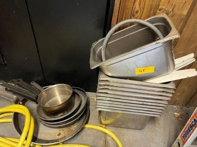 a pile of pots and pans sitting on the floor