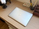 a laptop computer sitting on a wooden desk in front of a window