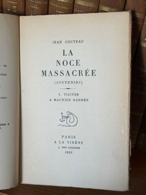 un livre ouvert sur une étagère, devant une pile de livres
