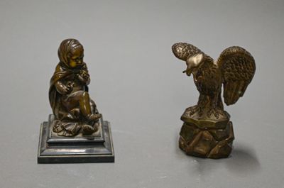 pair of antique bronze figurines of a woman and an eagle on a rock