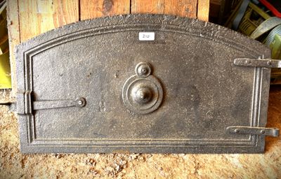 un vieux four en métal posé sur une table en bois