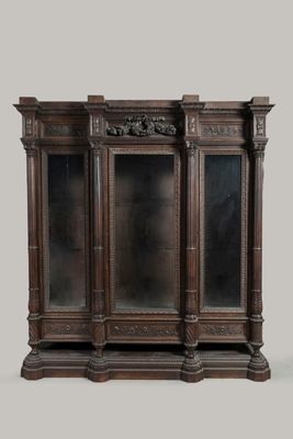 an image of a wooden display case with glass doors and carvings