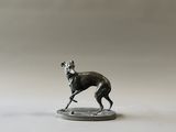figurine représentant un chien courant sur une pièce de monnaie, sur fond blanc
