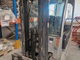 a fork lift truck in a warehouse with pallets