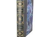 an old book with a blue cover sitting on a white surface
