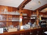 un comptoir en bois sur lequel sont posés de nombreux verres