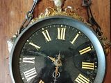 une horloge accrochée au mur, entourée d'une chaîne