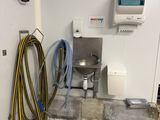a room with a sink and a hose on the floor