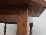 a close up of a wooden table with a drawer underneath it