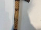 a large wooden axe hanging on the wall next to a shadow of a person