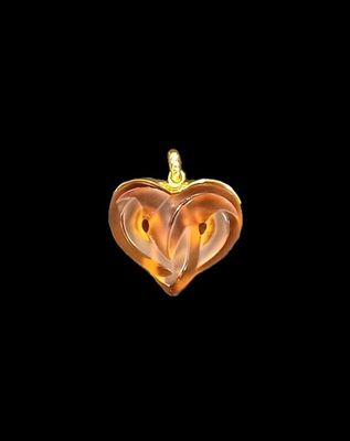 a close up of a heart shaped pendant on a black background