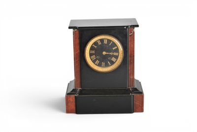 une horloge noire et dorée posée sur un socle en bois