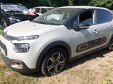 une petite voiture blanche garée sur l'herbe, dans le champ