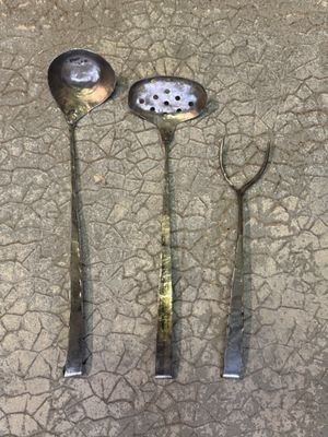 trois cuillères et une louche posées par terre