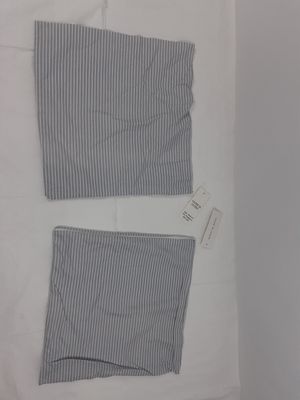 deux vêtements posés sur un lit, avec une étiquette dessus