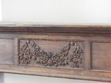 a wooden mantle with carvings on it in a room