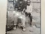 a picture of an old man and a young boy sitting on a bench