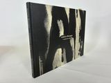a black and white photo of a book on a white surface
