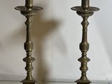 two candles that are sitting on a glass table