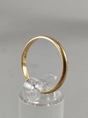 a close up of a gold ring with a green stone in it
