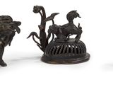 trois figurines en bronze représentant des animaux et un oiseau dans une cage