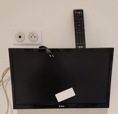 une télévision et une télécommande accrochées au mur
